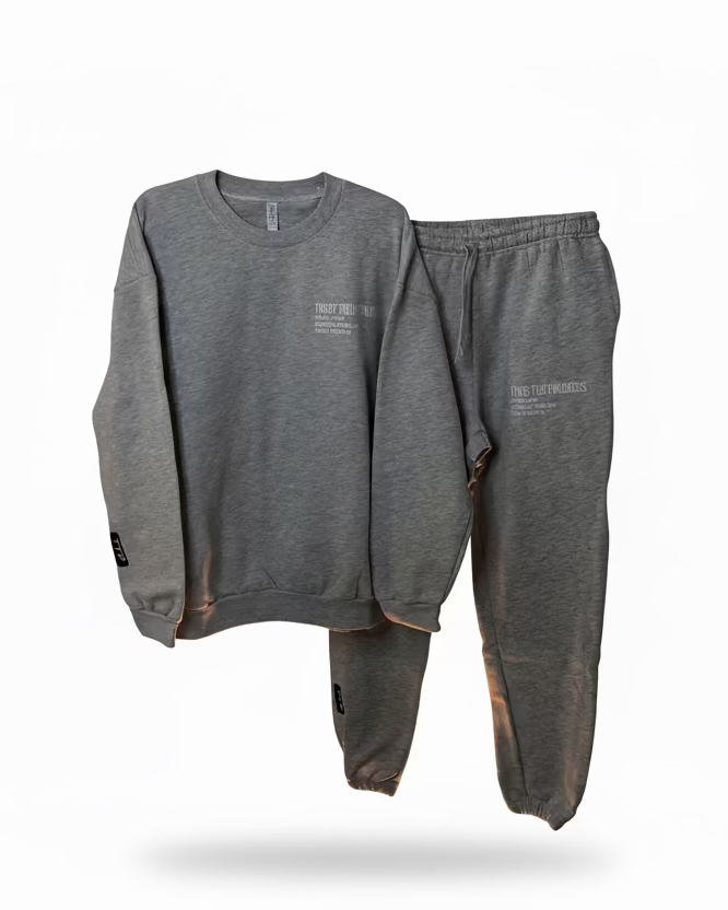 Gray sweatshirt and pants set on hangers against a plain background